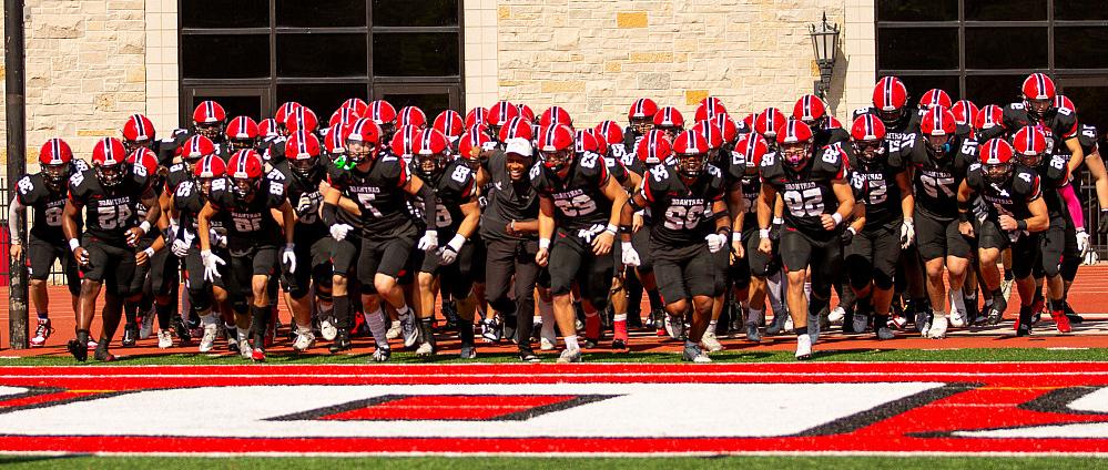 Carthage football players racing onto the football field.