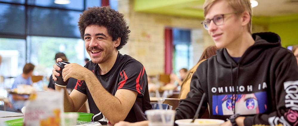 Two students enjoying a meal in the campus cafeteria.